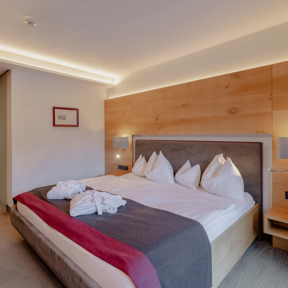 Modernes Hotelzimmer mit großem Bett und Holzvertäfelung