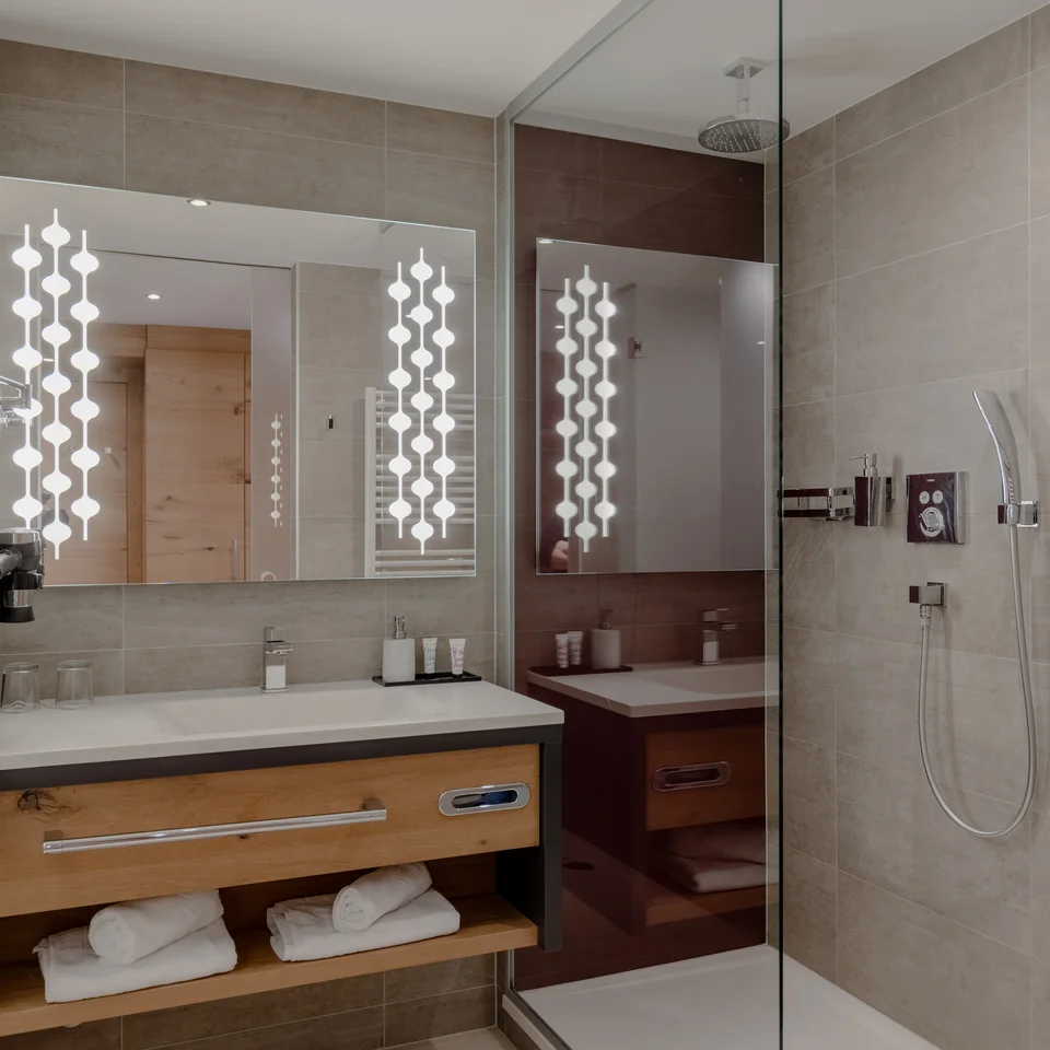 Elegant hotel bathroom with illuminated mirror and shower