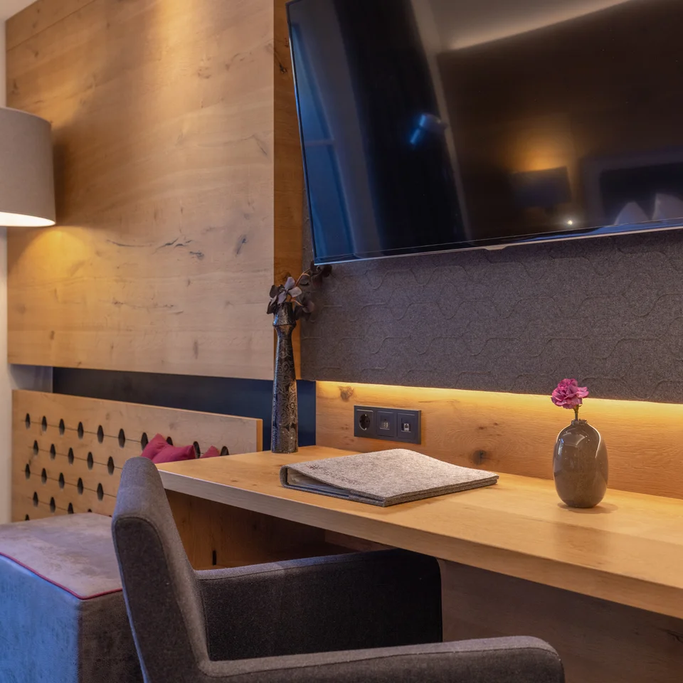 Modern hotel room with desk and wall-mounted TV