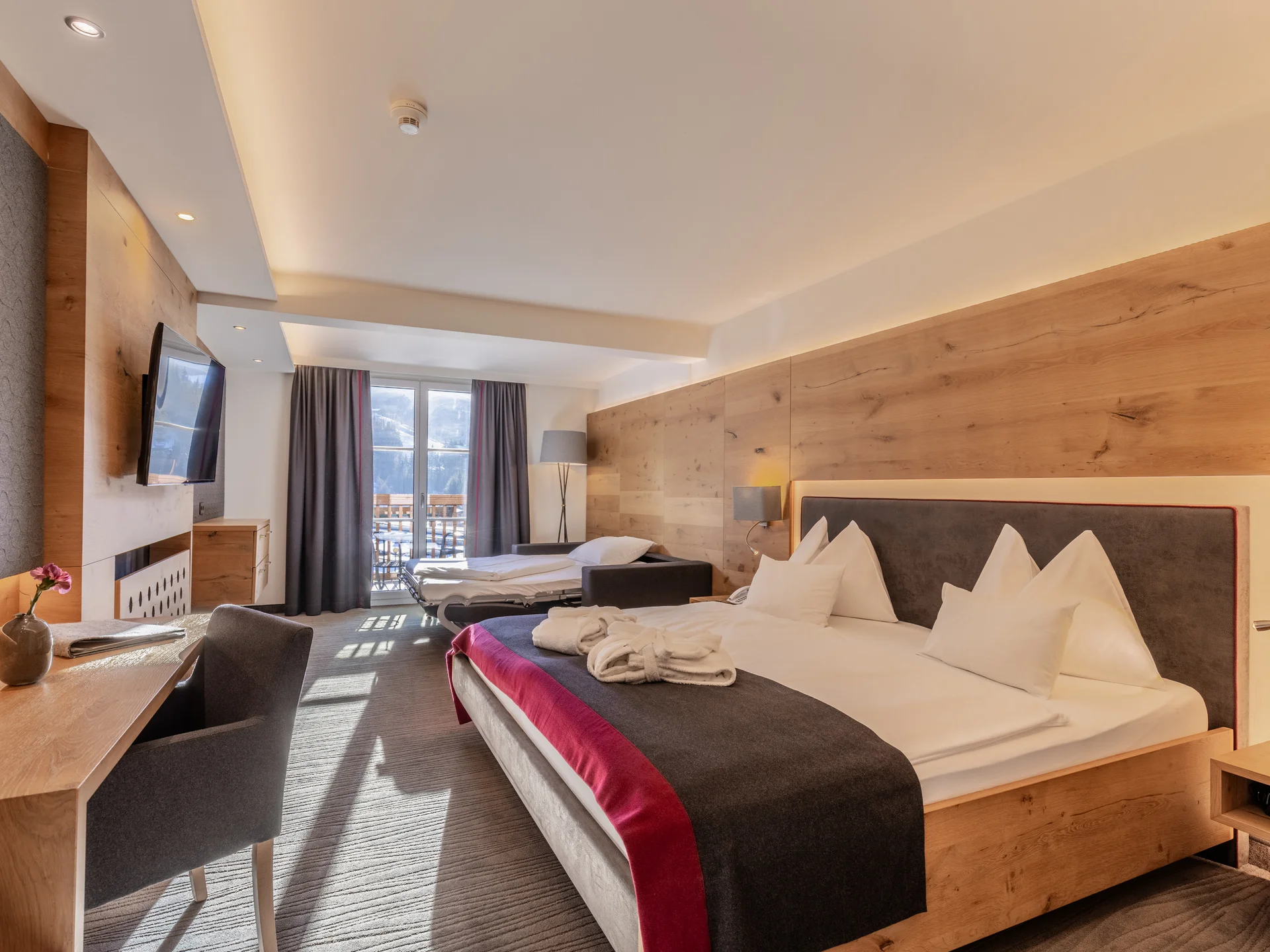 Modern hotel room with a balcony view of snow-covered mountains