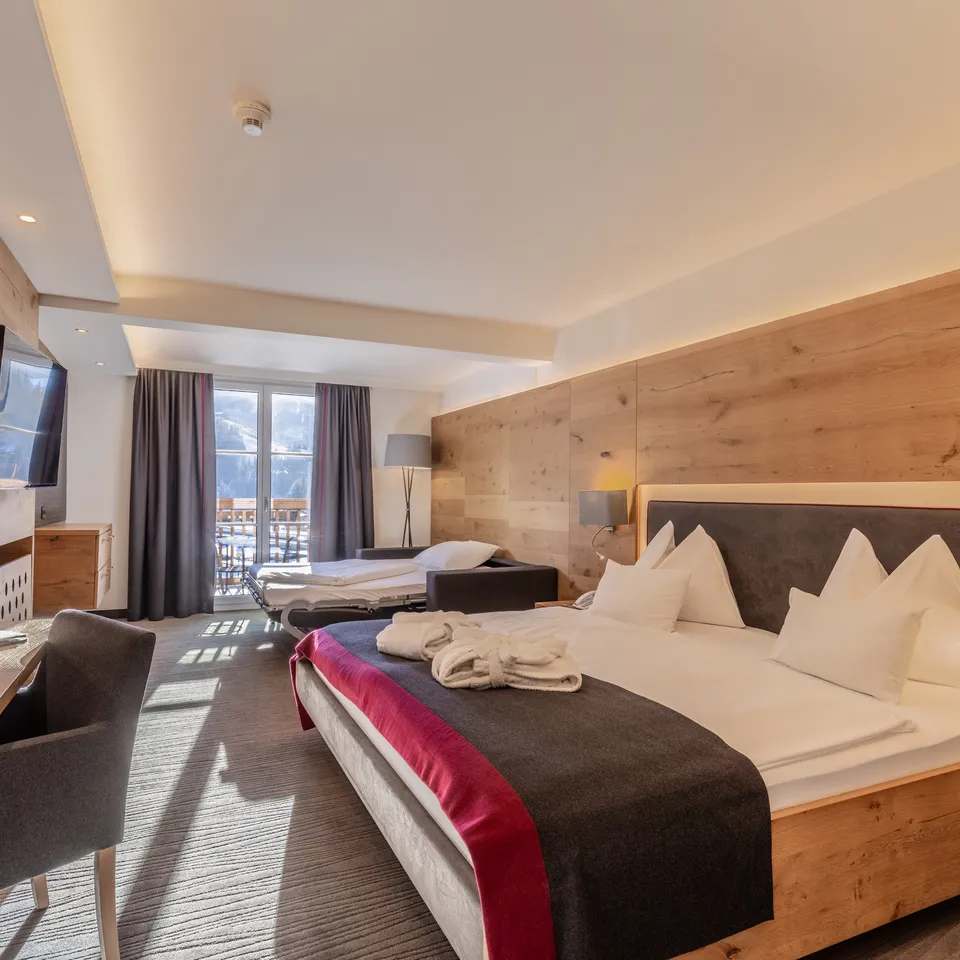 Modern hotel room with a balcony view of snow-covered mountains