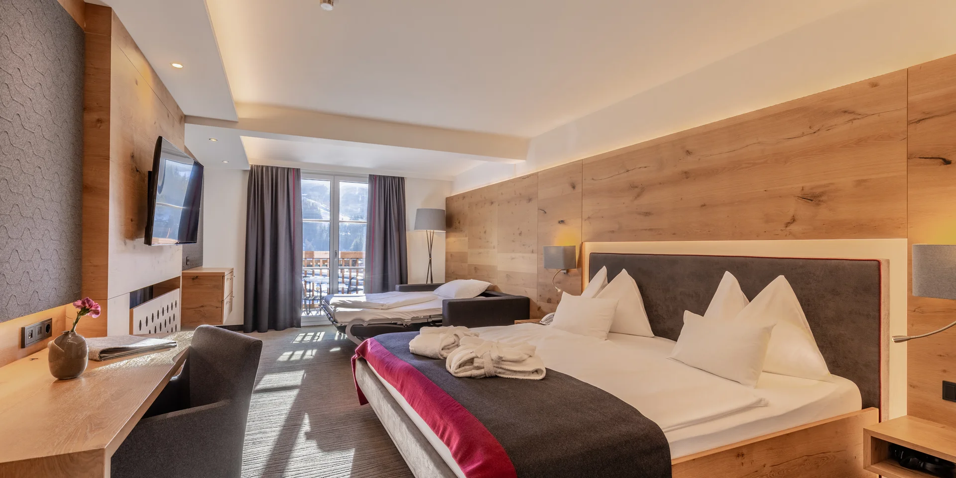 Modernes Hotelzimmer mit Balkonblick auf verschneite Berge