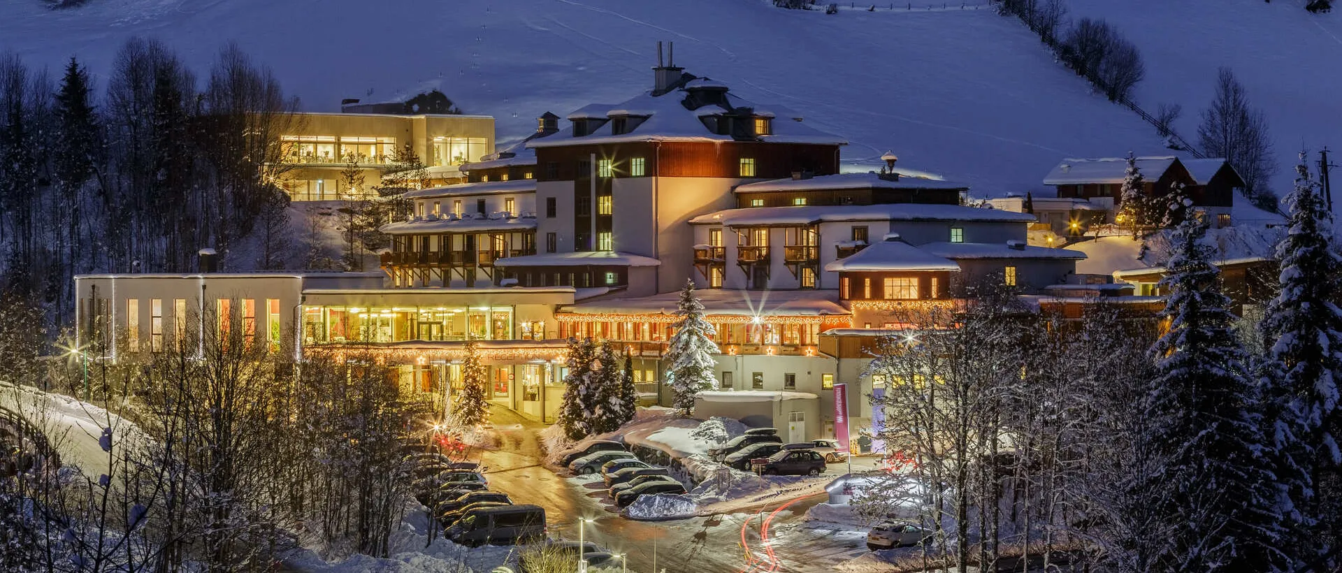 Sporthotel Wagrain im Winter, Außenansicht bei Nacht, beleuchtet, verschneite Landschaft