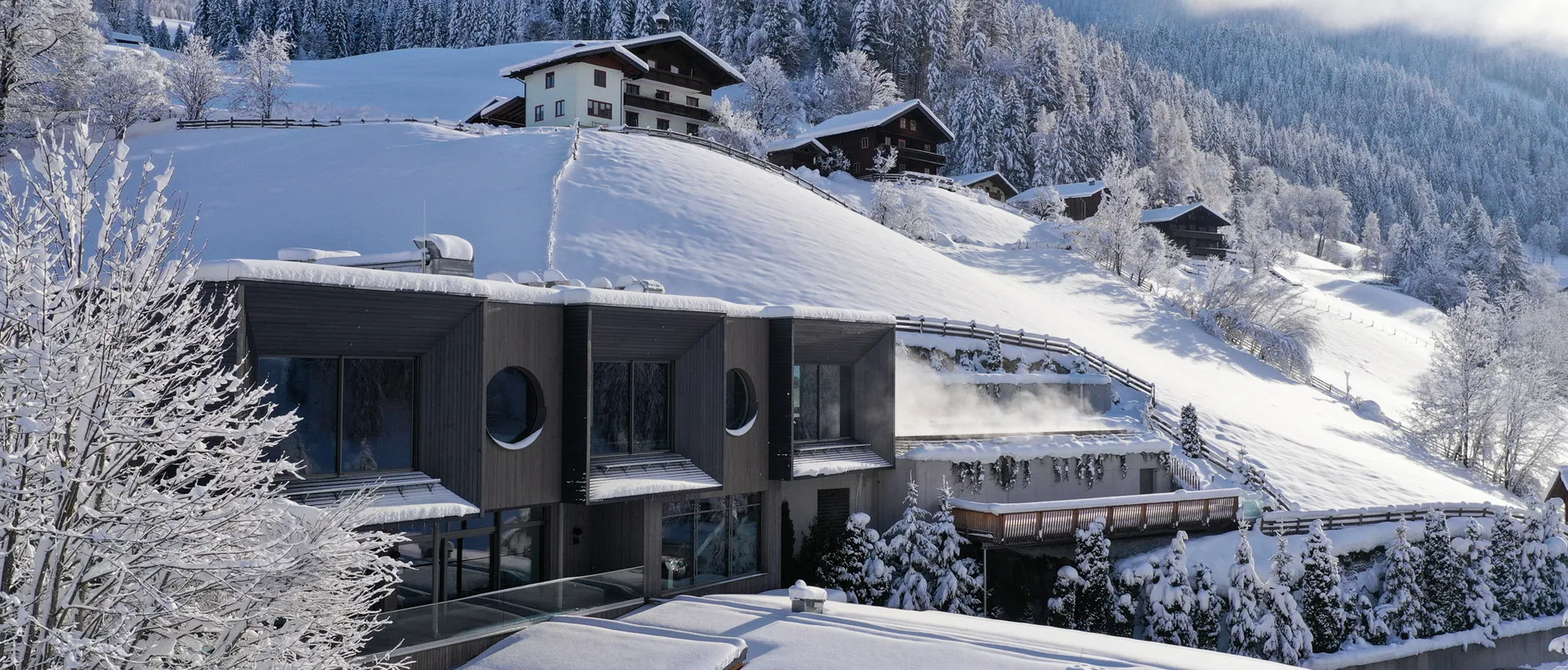 Sporthotel Wagrain mit schneebedeckten Häusern und Bergen im Hintergrund