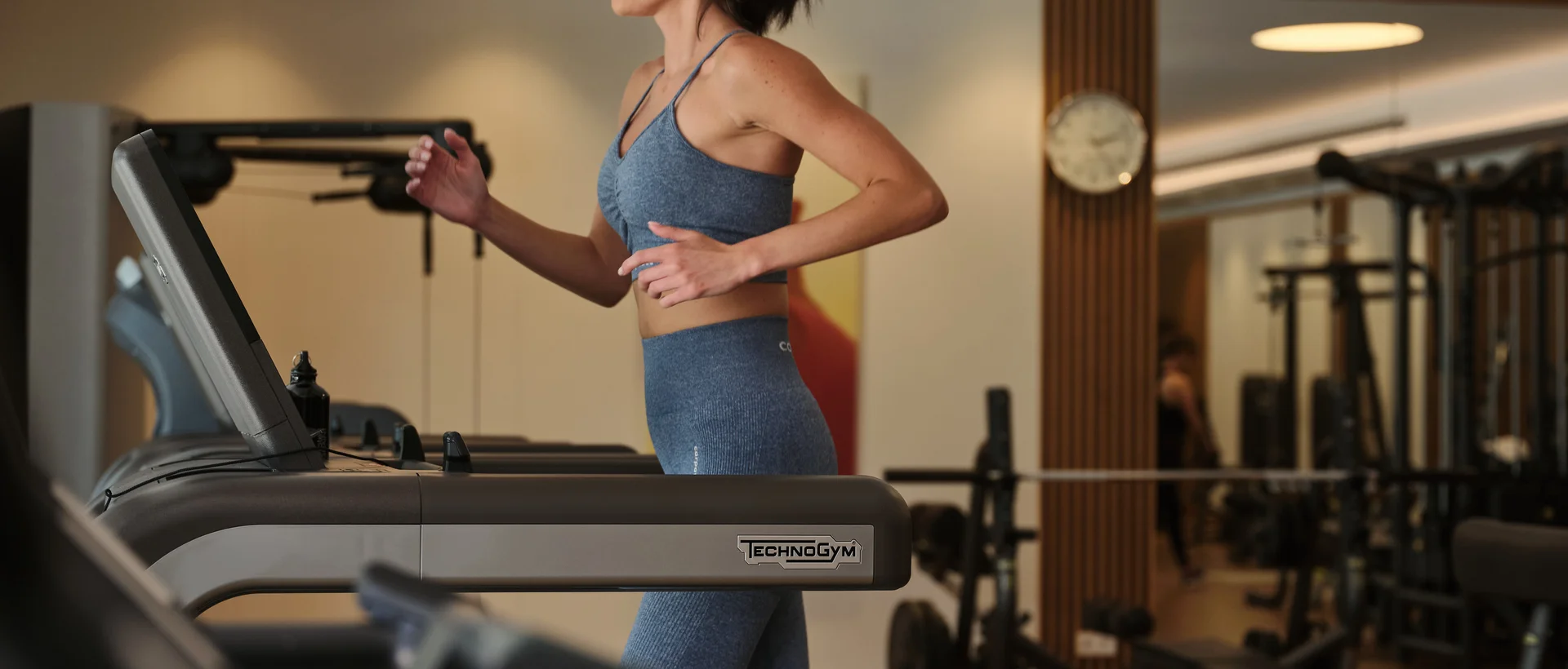 Frau joggt auf einem Laufband in einem Fitnessstudio