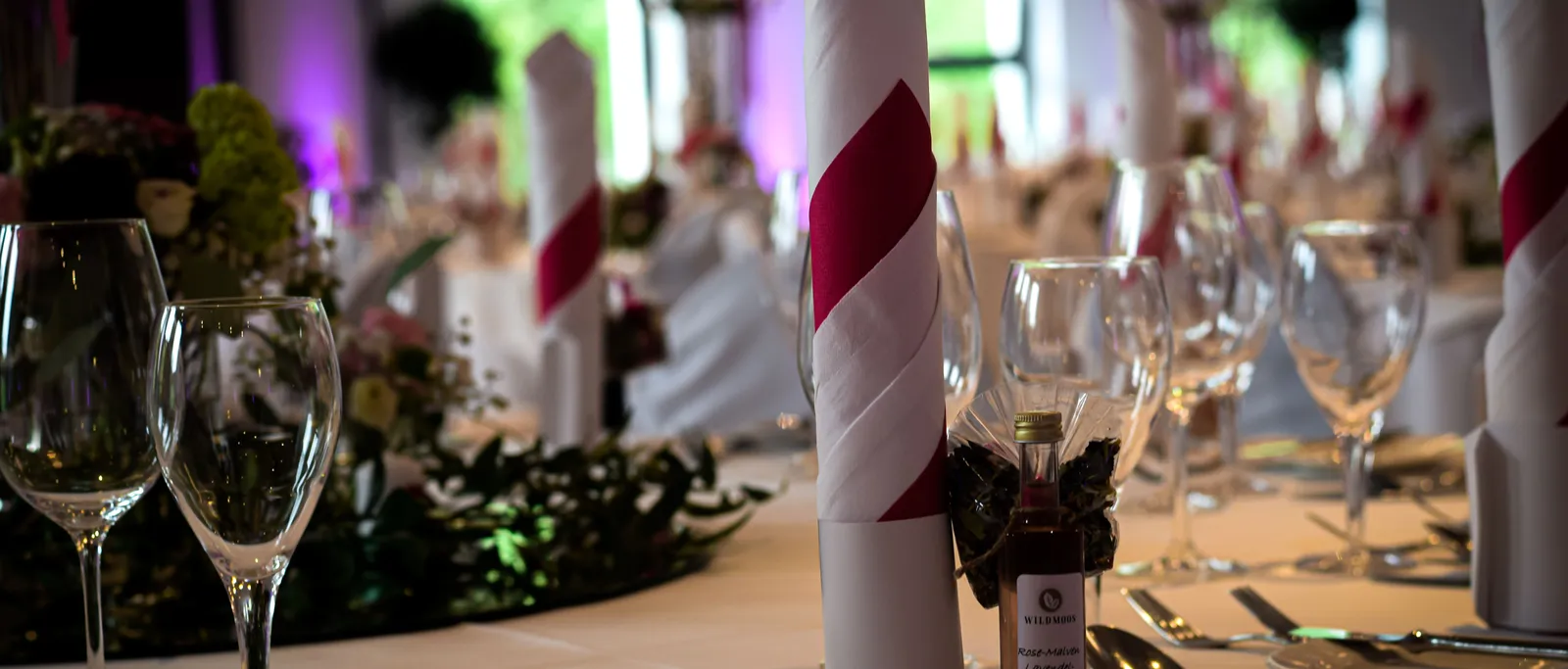 Festlich gedeckter Tisch mit Serviette, Besteck und kleinem Fläschchen