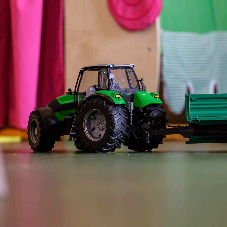 Toy tractor with trailer on the floor