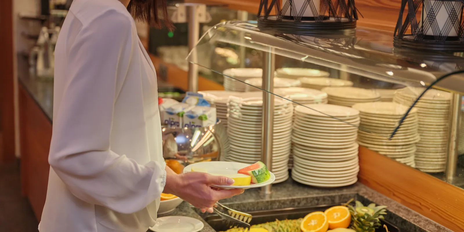 Woman taking fruit from the buffet at Sporthotel Wagrain