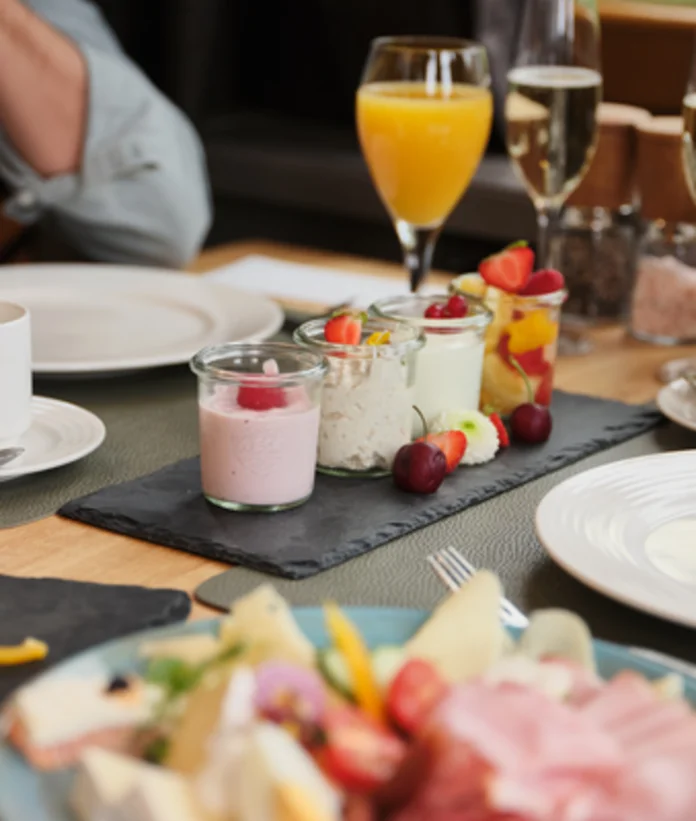 Set breakfast table with yogurt, fruit, juice and champagne glasses at the Sporthotel Wagrain