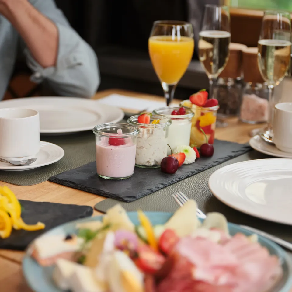 Gedeckter Frühstückstisch mit Joghurt, Obst, Saft und Sektgläsern im Sporthotel Wagrain