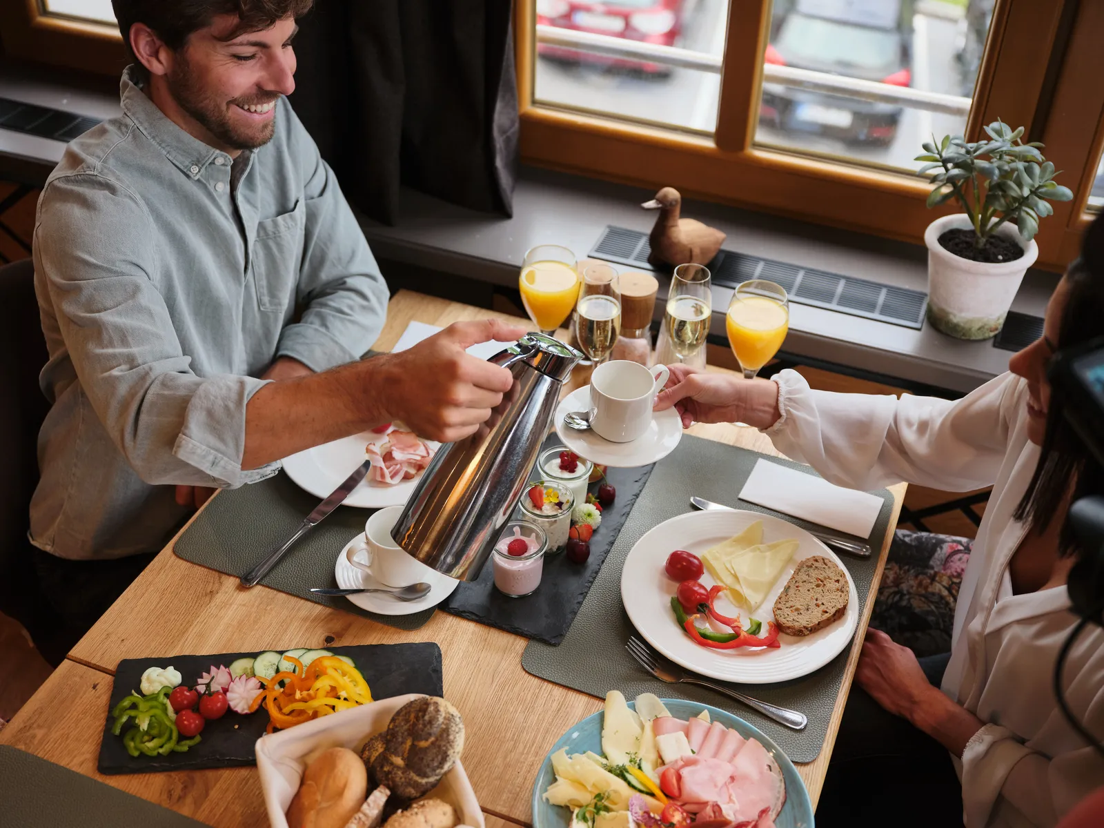 Mann gießt Kaffee beim Frühstück im Sporthotel Wagrain ein