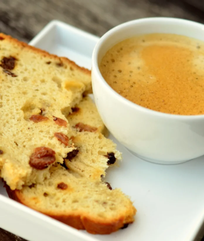 Piece of cake and cup of coffee on a white plate