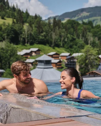 Couple in the pool with a view of Wagrain and the mountains