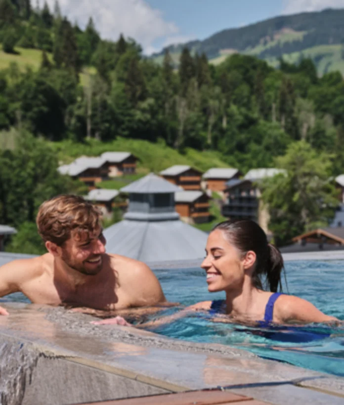 Paar im Pool mit Blick auf Wagrain und die Berge