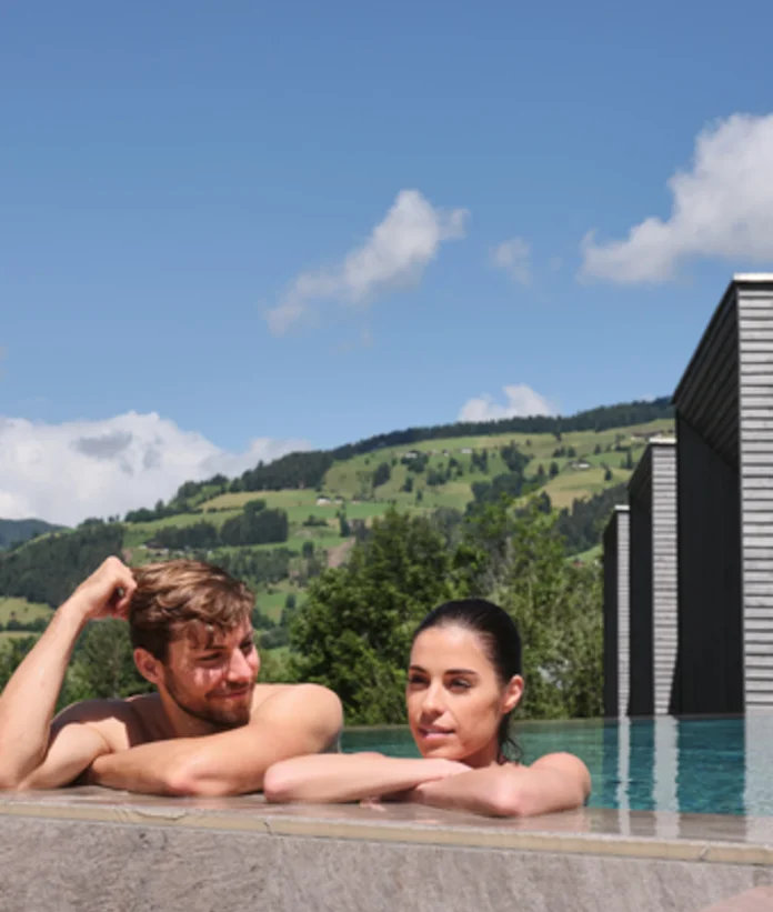 Couple in the pool with mountain view at Sporthotel Wagrain