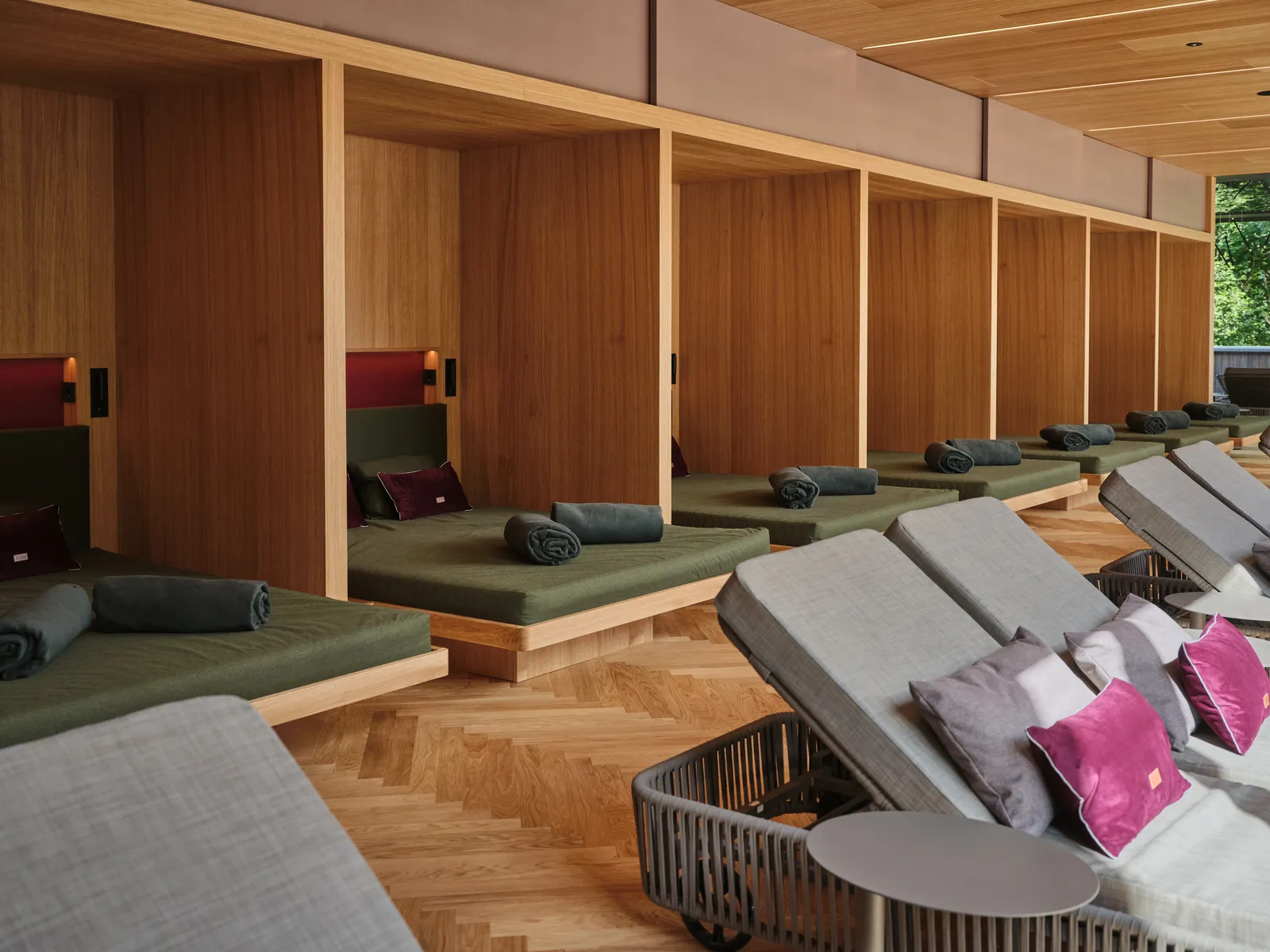 Relaxation area with loungers in wooden cabins and deck chairs on parquet floor