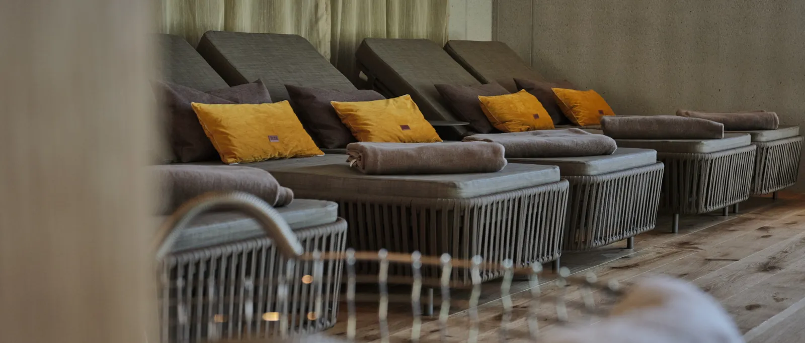 Grey loungers with yellow cushions in a relaxation room