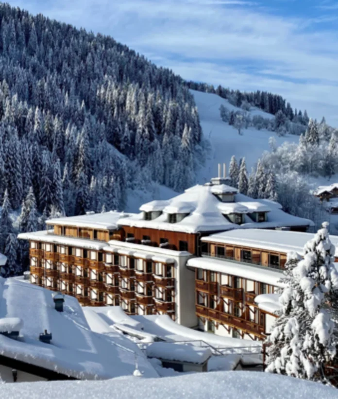 Sporthotel Wagrain  in winter in front of a snow-covered forest slope