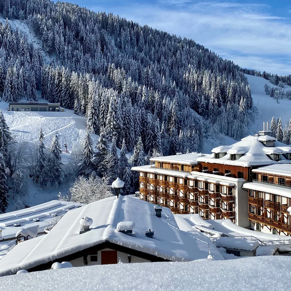 Sporthotel Wagrain  im Winter vor schneebedecktem Waldhang