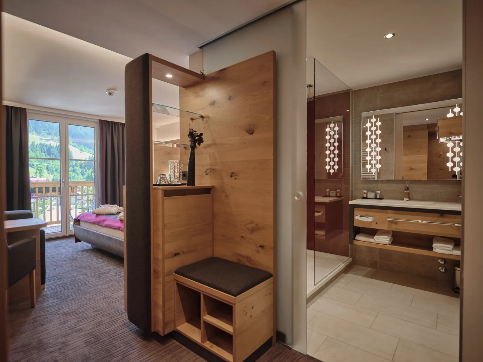 Hotelzimmer mit Holzelement, Bett, Bad und Ausblick