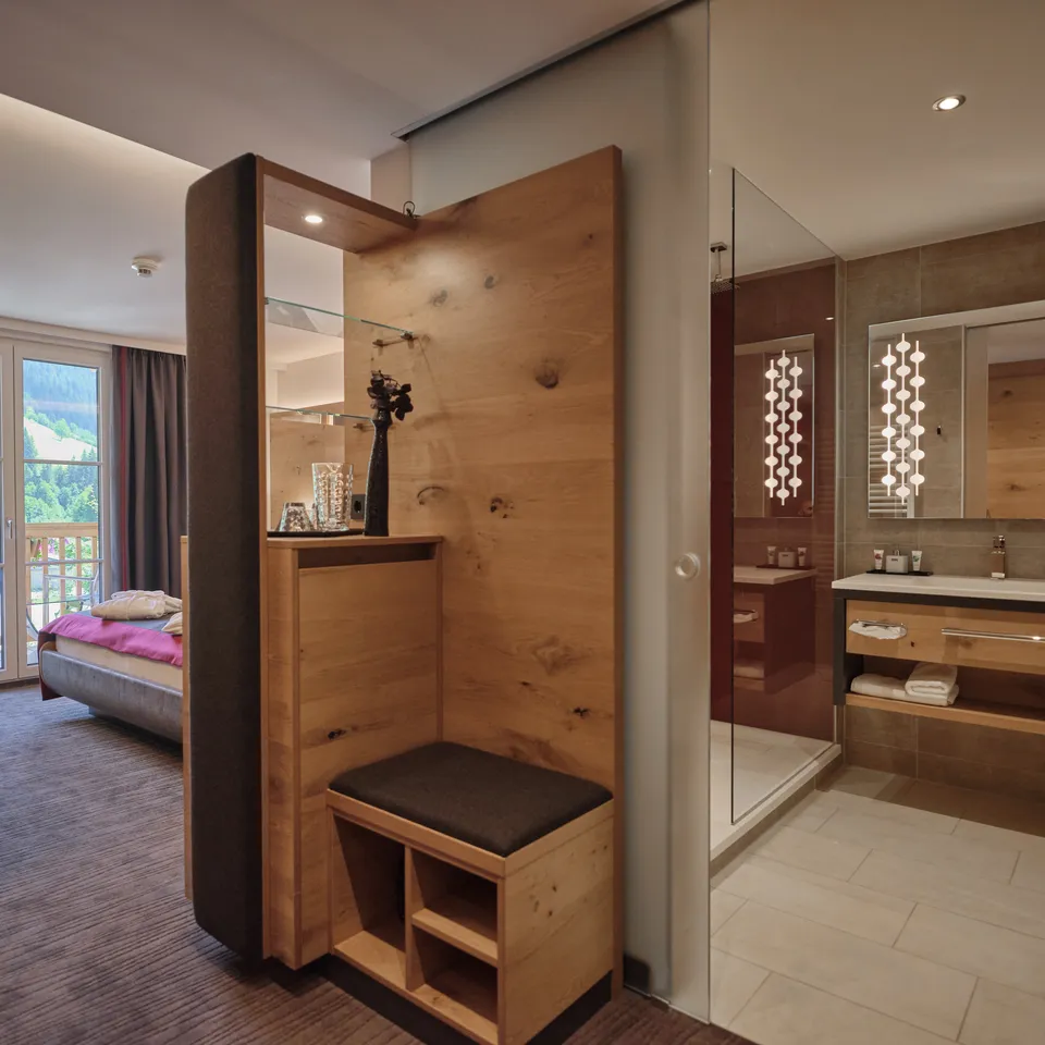 Hotelzimmer mit Holzelement, Bett, Bad und Ausblick