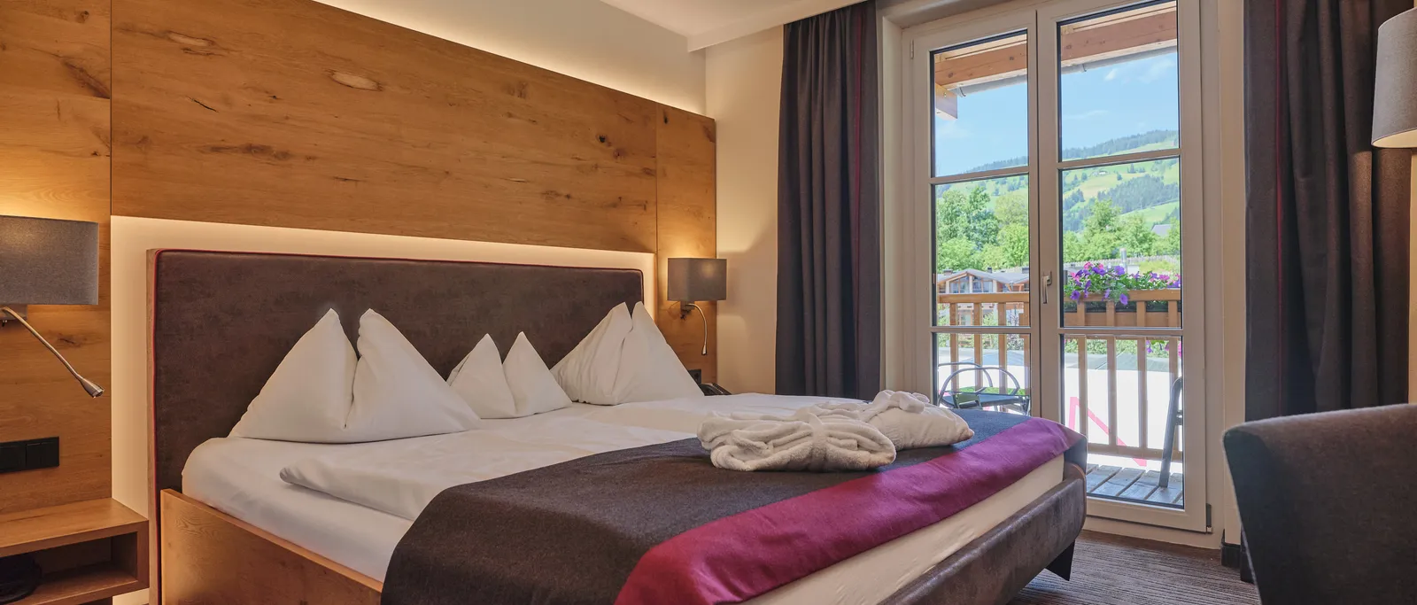 Hotel room with double bed and balcony overlooking the greenery