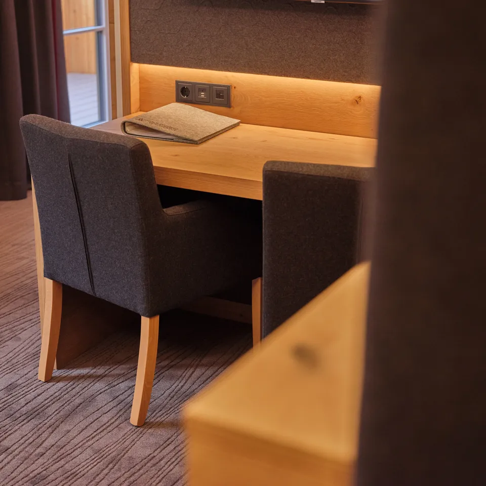 Schreibtisch mit Stuhl und Ablage in einem Hotelzimmer
