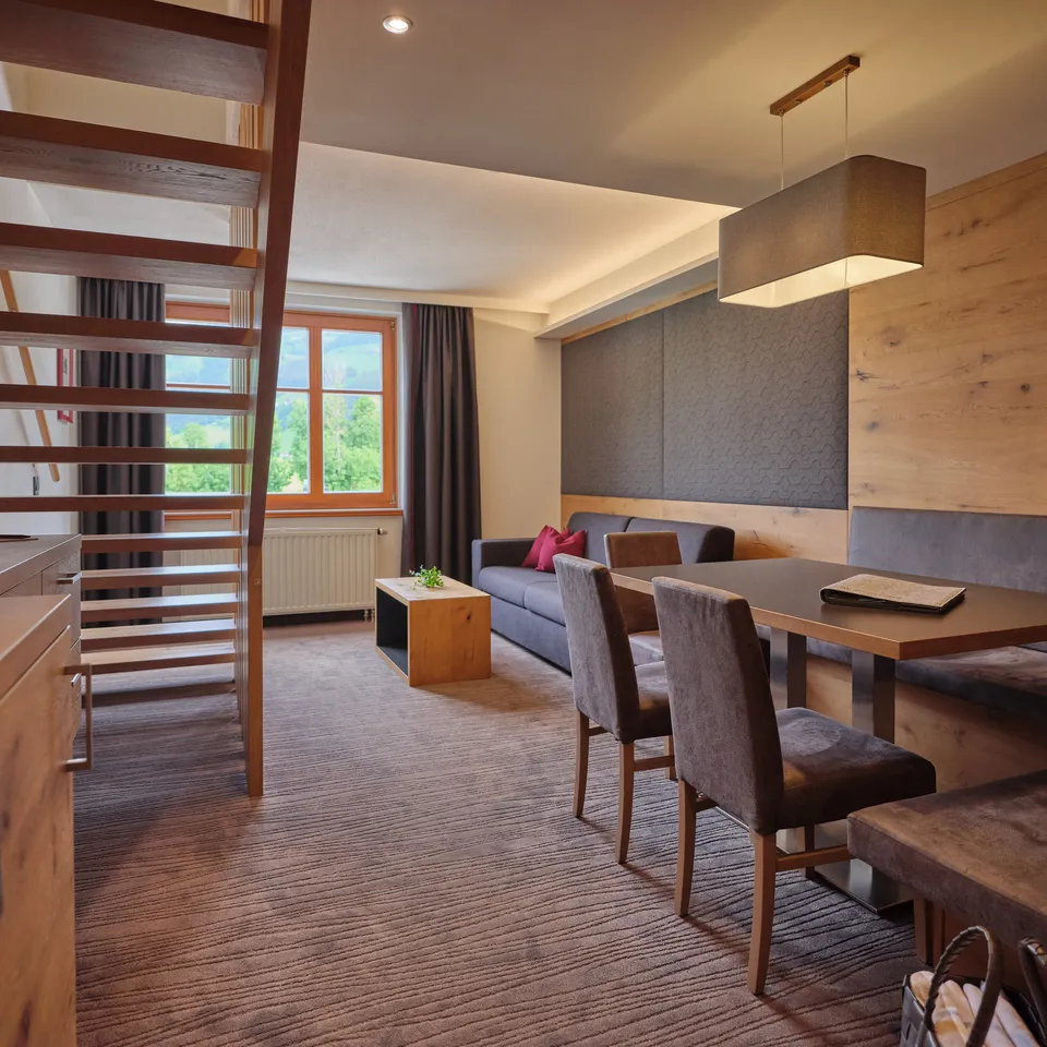 Bright apartment with stairs, sofa, table, chairs and window