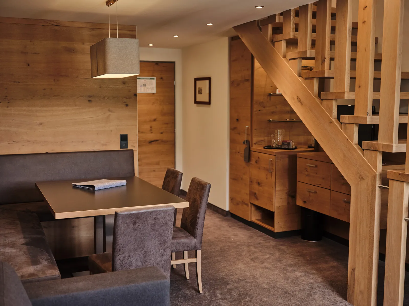 Helle Ferienwohnung mit Holzelementen, Esstisch, Treppe und Einbauschränken