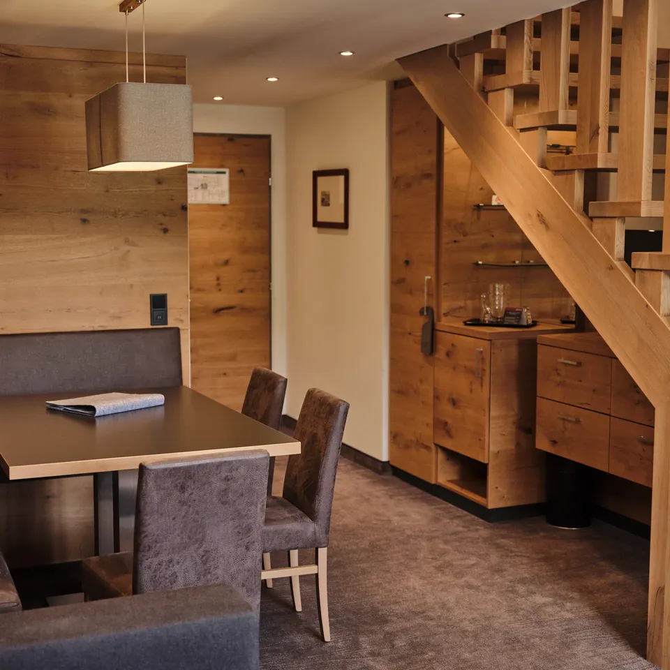 Bright holiday apartment with wooden elements, dining table, staircase and fitted wardrobes