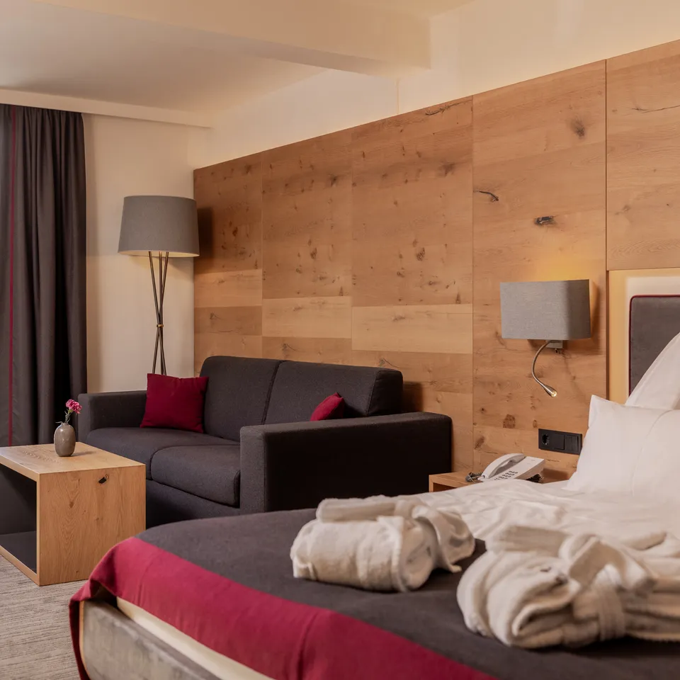 Modern hotel room with balcony, bed and sofa