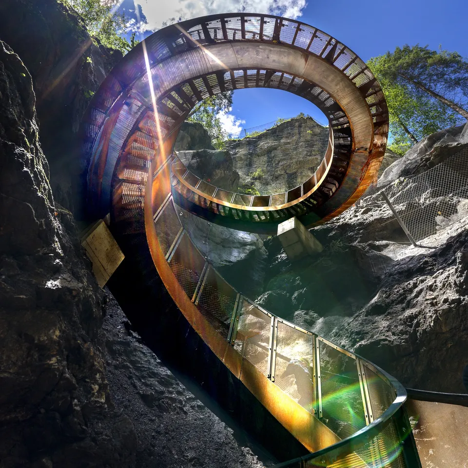 Spiral staircase in a crevice with a view of the sky