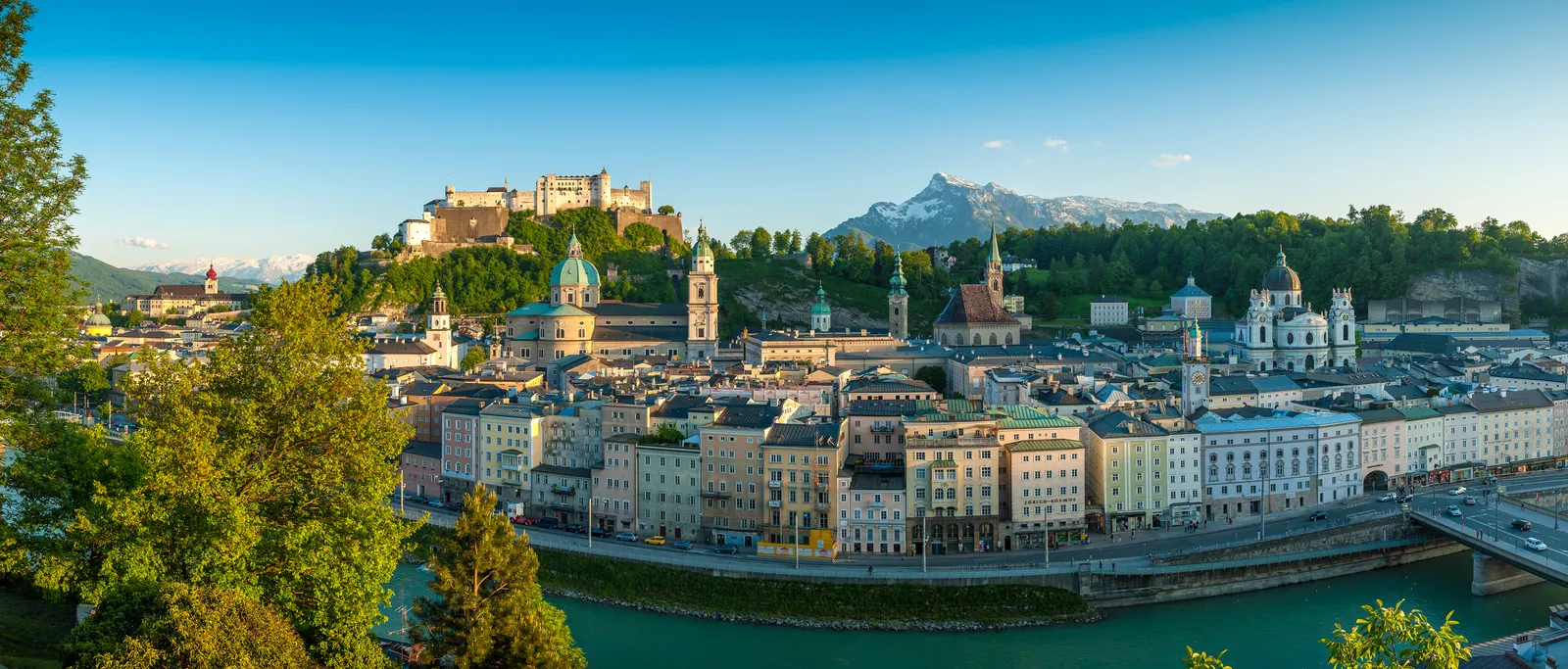 Salzburg im Sommer: Blick auf die Altstadt mit Festung Hohensalzburg und Salzach unter blauem Himmel