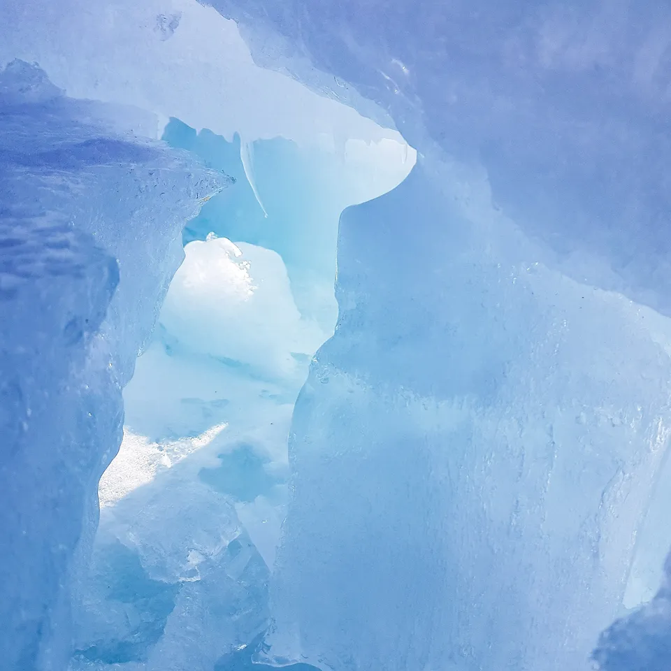 Ice caves with bluish shimmering ice caves and bright light gap
