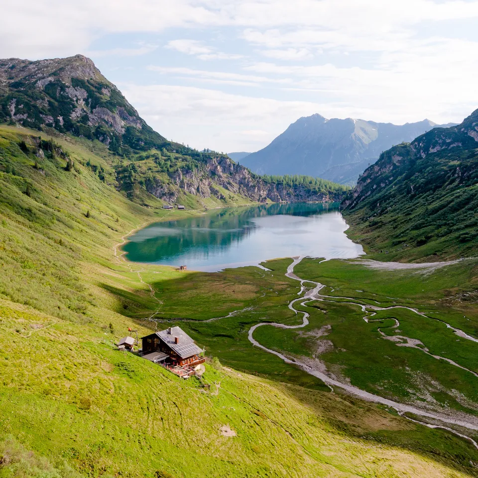 Tappenkarsee in Wagrain-Kleinarl mit Hütte, umgeben von grünen Hängen und Bergen