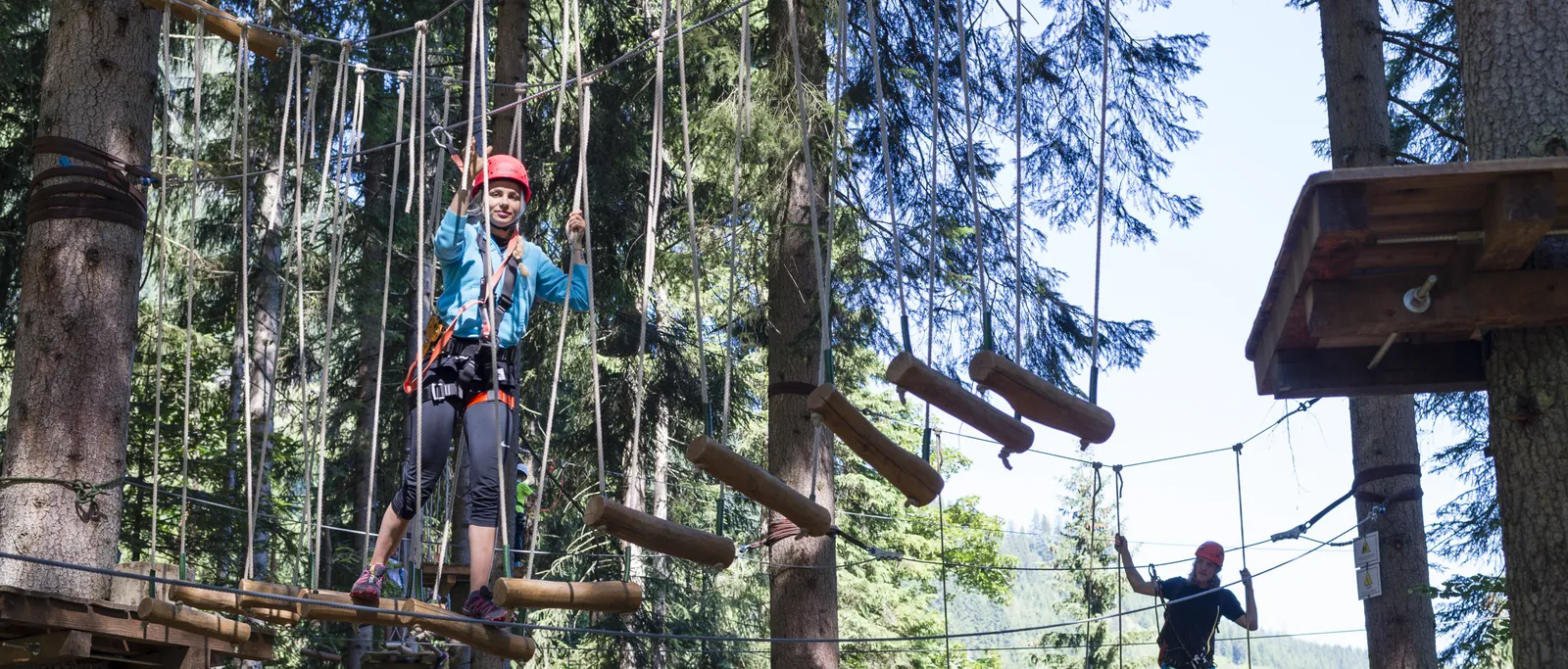 Personen auf Hängebrücken im Hochseilgarten zwischen Bäumen in Wagrain-Kleinarl