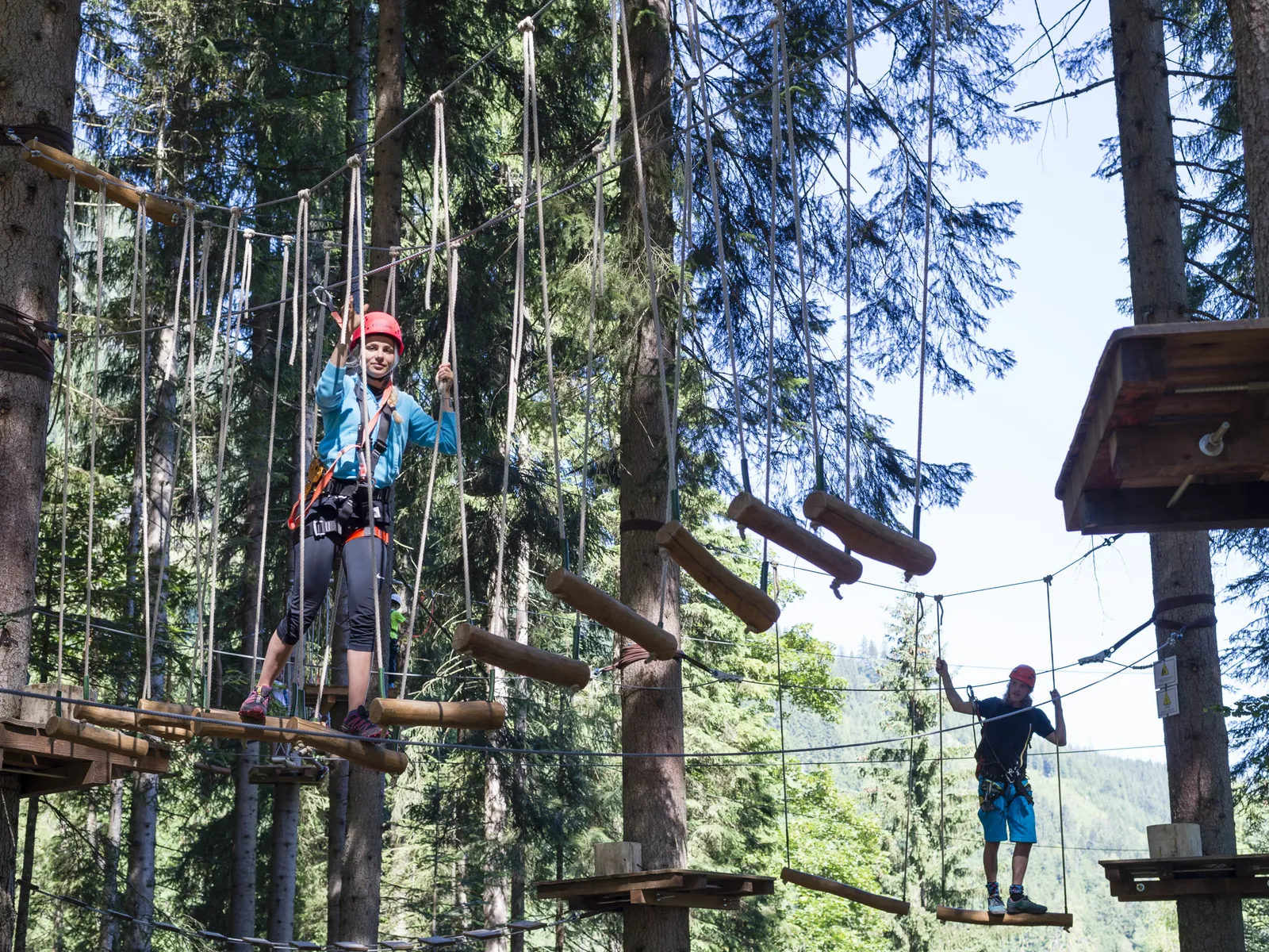 Personen auf Hängebrücken im Hochseilgarten zwischen Bäumen in Wagrain-Kleinarl