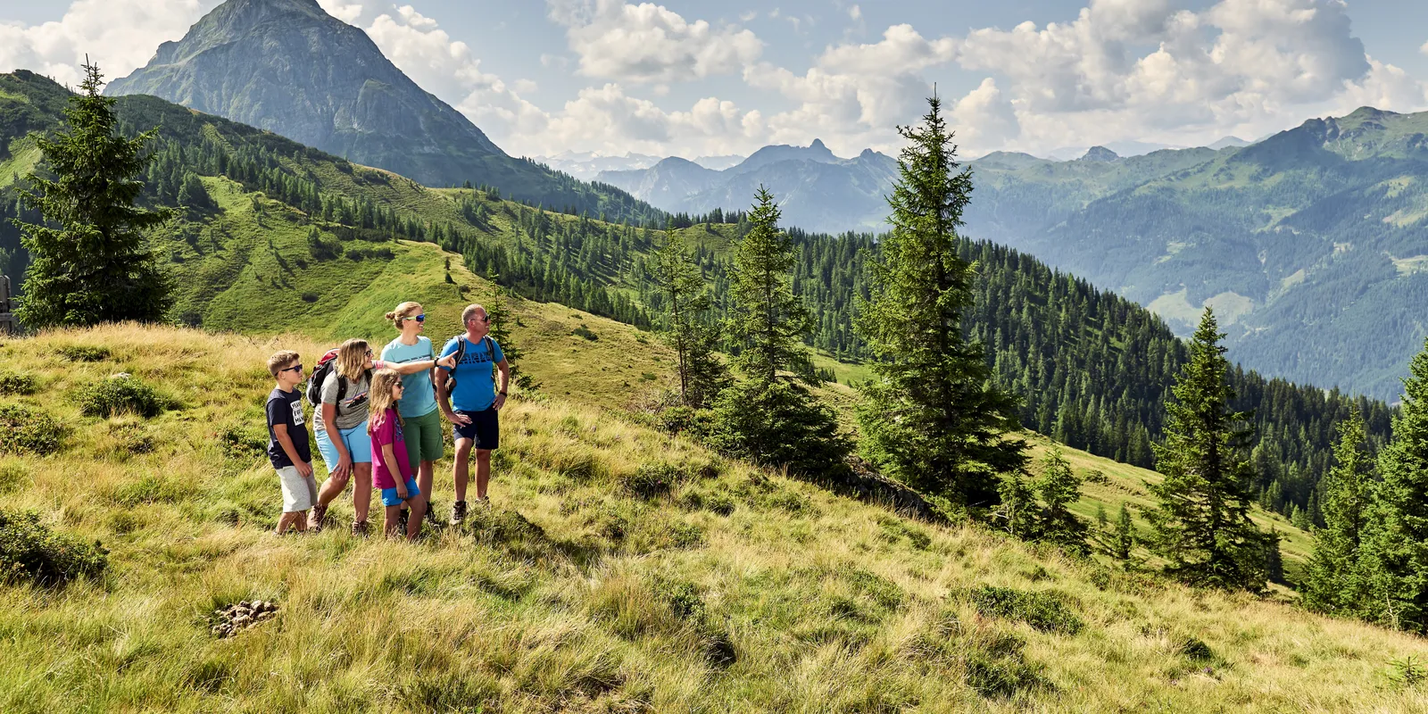Familie mit Wanderführerin wandert in Wagrain-Kleinarl vor Bergpanorama