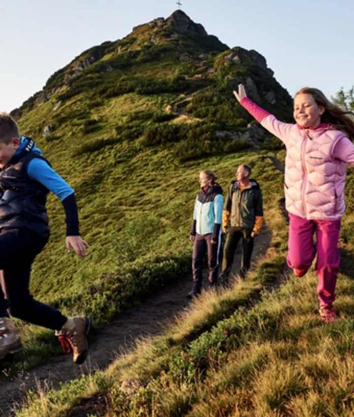 Hiking family on mountain trail in front of the Griessenkareck in Wagrain