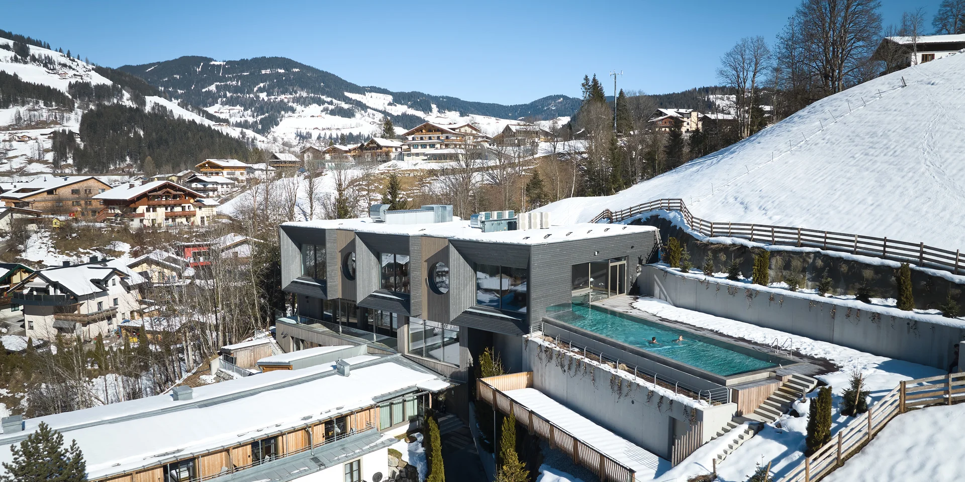 Sporthotel mit Pool im Schnee, aufgenommen mit einer Drohne
