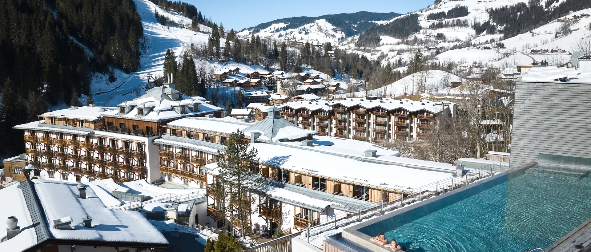 Sporthotel Wagrain im Winter mit Schnee, Pool und Bergen im Hintergrund