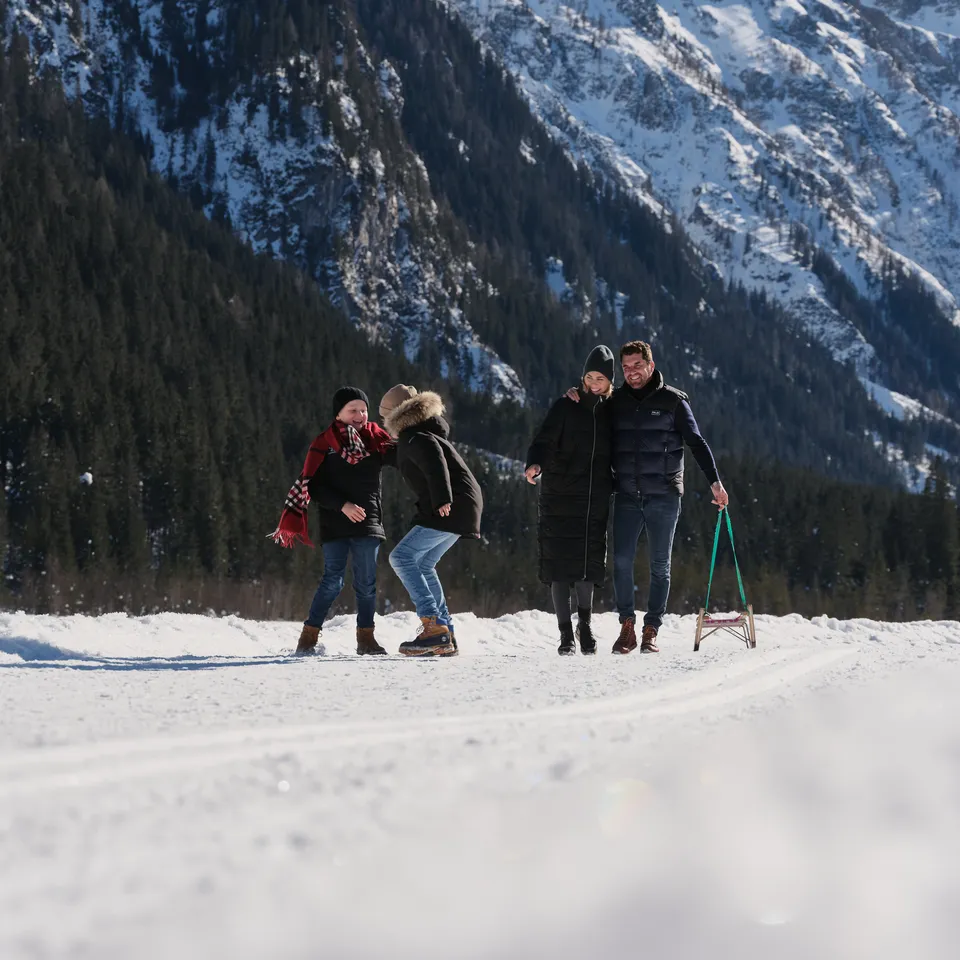 Family in the snow in front of a mountain backdrop