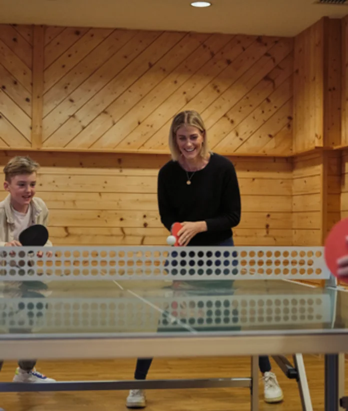 Woman and boy playing table tennis at Sporthotel Wagrain