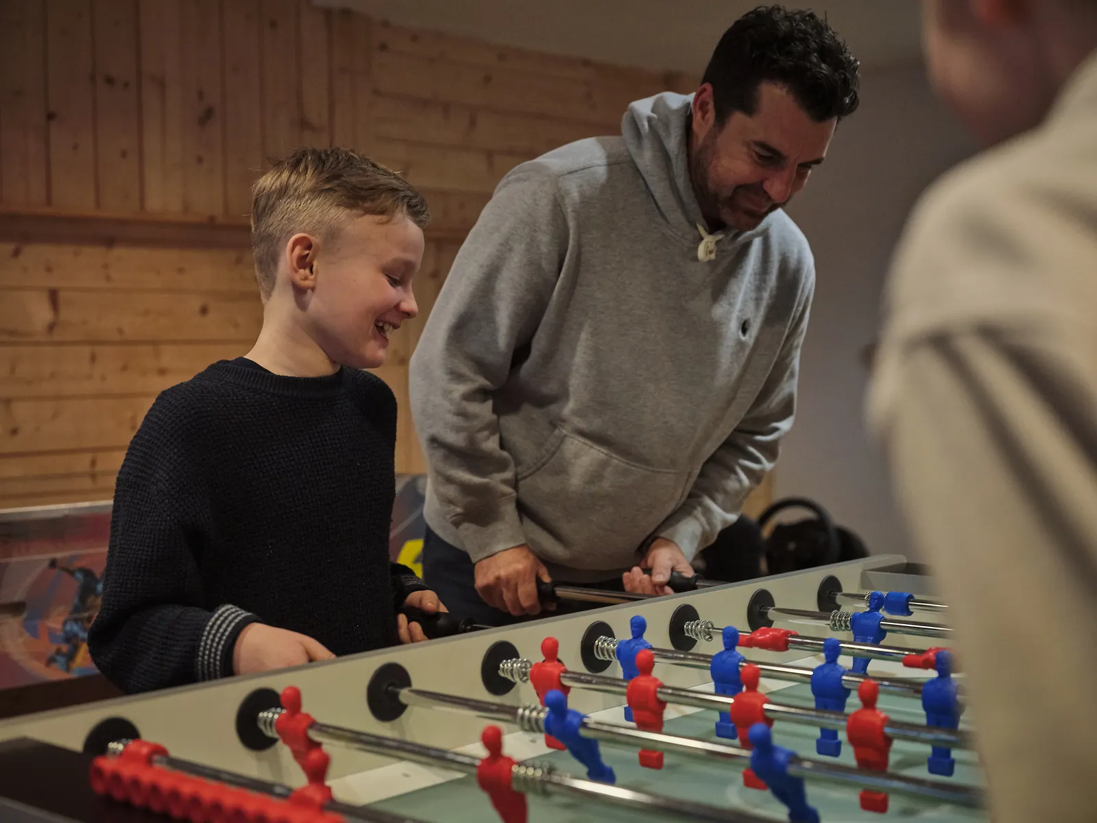Vater und Sohn spielen Tischfußball und lachen