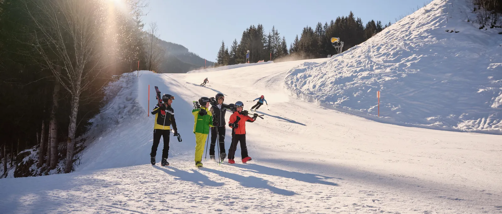 Gruppe Kinder mit Skiern auf Skipiste an sonnigem Wintertag