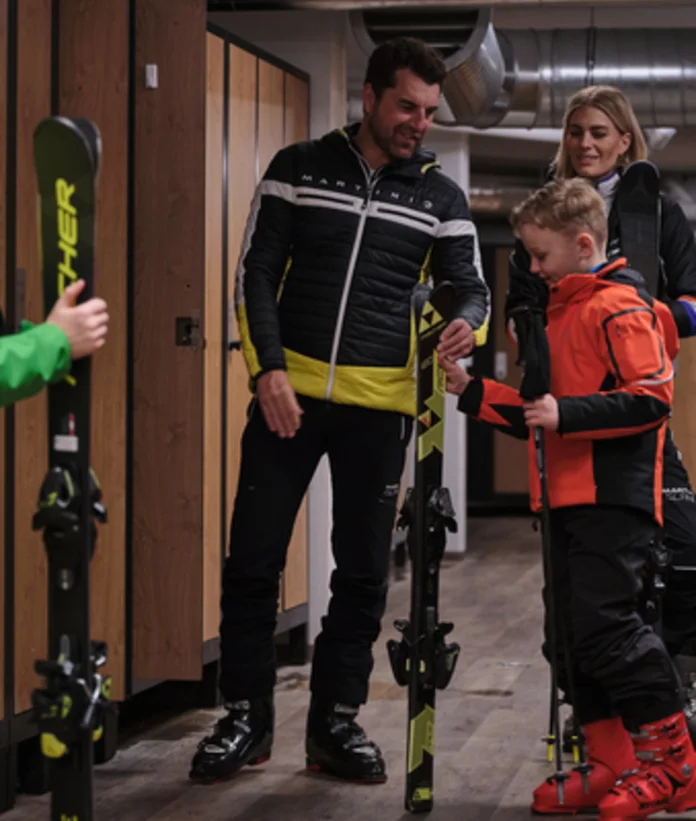 Familie mit Skiern im Skikeller des Sporthotel Wagrain